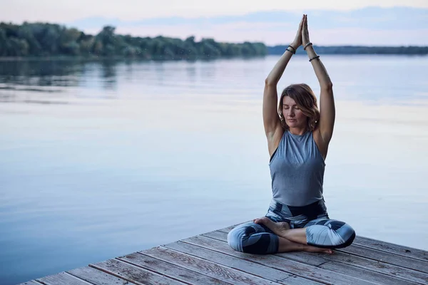 Calm Woman Lotus Pose Sits Dock Practices Yoga Breathing River — ストック写真