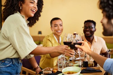 Multicultural friends toast with wine in the restaurant during dinner.