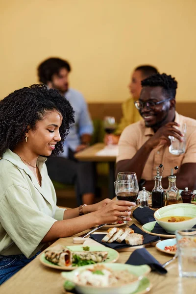 A multicultural friends are having dinner with friends in a restaurant.