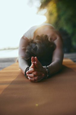 A woman practices yoga on the dock.
