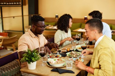 Friends eat dinner in a restaurant.