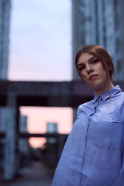 Gökdelenlerle çevrili şehir dışında genç bir kız duruyor..