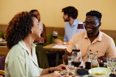 A multicultural friends are having dinner in a restaurant.
