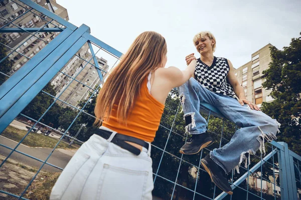 Ein Teenager Hilft Seiner Freundin Über Den Zaun Klettern — Stockfoto