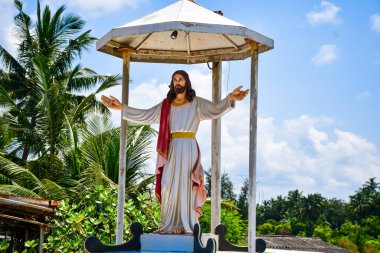 İsa 'nın heykeli, kollarını açık bir bahçede uzatmış.