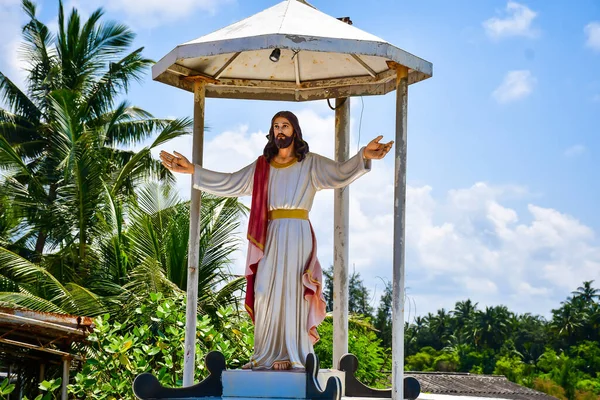 İsa 'nın heykeli, kollarını açık bir bahçede uzatmış.