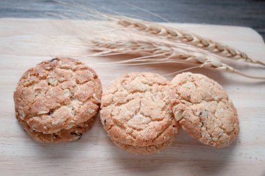 Üç lezzetli yulaf ezmeli kurabiye ve çivili tahta kesme tahtası.. 