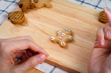 Fırıncı adam Noel kurabiyelerini renkli krema şekeri ile dekore ediyor, ev yapımı zencefilli kurabiye yapıyor, Xmas kurabiyesi yapıyor, fırın hazırlıyor, evde pişirme ve pişirme işlemi yapıyor..