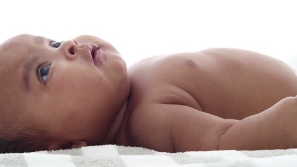 小さなアジア系アフリカ人の新生児 3ヶ月 赤ちゃんの女の子はベッドの上に横たわっています 彼女の顔と目を移動します 彼女は非常にリラックスしているので 腹呼吸を持っています — ストック動画