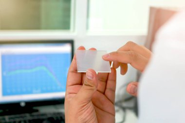 Ultraviyole ölçer kullanarak kozmetiğin radyasyon korumasının ölçümü için UV güneş kremini uygulamak için elde tutulan PMMA akrilik plakası.