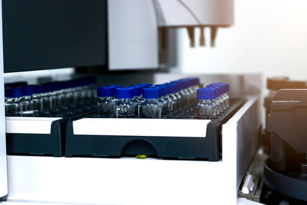 Vials (small bottle) in tray inside injection section of Gas Chromatography (GC) instrument, chemistry analytical experiment concept