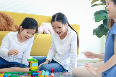 İki kız çocuğu, anneleriyle tahta blok oyunu (Jenga) oynuyorlar, kız kardeşi ise annenle özel bir an yaşıyor ve birlikte vakit geçiriyorlar.. 