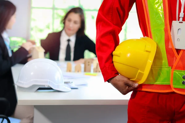 Engenheiro Vestindo Colete Segurança Segurando Capacete Frente Mesa Reunião Com — Fotografia de Stock