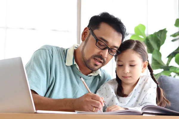 年轻英俊的爸爸教可爱的女儿做作业 在家里用笔记本电脑进行电子学习 爸爸和孩子在一起学习和上网 — 图库照片