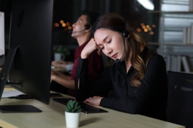 Çağrı merkezi Asyalı kadın çalışanları çağrı merkezinde çalışan çağrı merkezi danışmanı müşteriler şikâyet ettiği için üzülüyorlar, geceleri çalışıyorlar üzgün, yorgun ve bitkin, mutsuz işçi konsepti.
