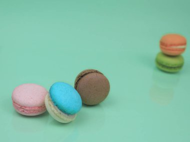 Renkli Fransız badem kurabiyeleri (badem kurabiyeleri), yeşil zemin üzerinde tatlı tatlı, kopyalama alanı, gıda arka plan konsepti.