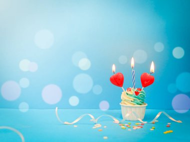 Tatlı kek ve mavi arka planda fiyonk mum ve fotokopi alanı. Mutlu yıllar.