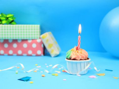Tatlı kek ve mavi arka planda fiyonk mum ve fotokopi alanı. Mutlu yıllar.