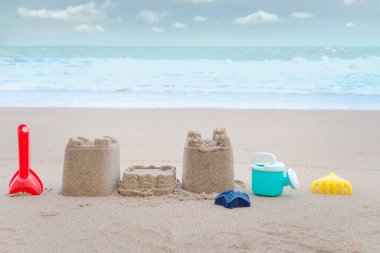 Kumdan kale ve kumdan oyuncaklar tropikal kumlu yaz okyanus sahillerinde kumdan kale yapmak için arka planda güzel mavi gökyüzü, açık deniz adasında dinlendirici tatil.