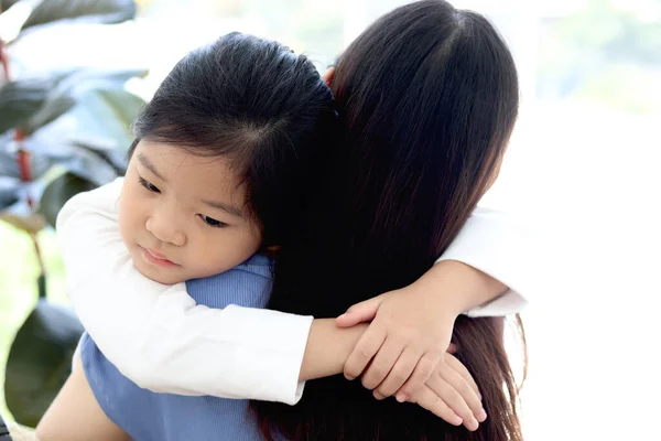 Adorable cute Asia girl daughter feeling sick and hugging her mom with love, warm love in family, mom taking care of sad kid has cold, Happy mother day.