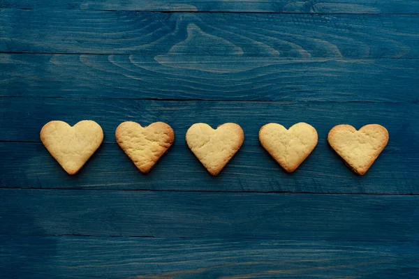 Rangée Cinq Biscuits Coeur Sur Fond Bleu Bois Photo Horizontale — Photo