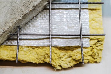 Yerleri ve duvarları yalıtmak için mineral yününden yapılmış termal yalıtım malzemesi. Beton bir zemine doğru yerleştirme yönergeleri. Yakın plan.