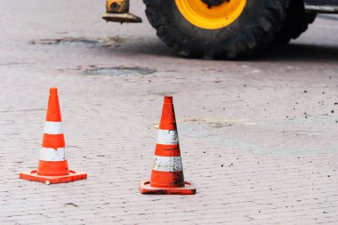 Özel ekipman tekerlerinin arka planında trafik konileri. Yaya kaldırımında tamirat. Yakın plan.