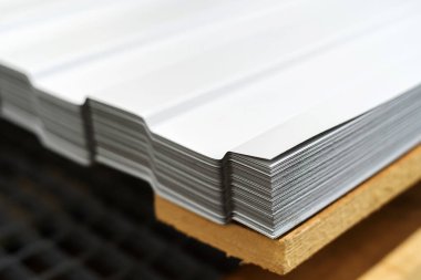 Metal corrugated board. A stack of roofing sheets is in the store's warehouse. Close-up. Copy space