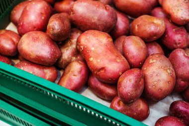 Red potatoes in a plastic box. Selling vegetables in a store. Close-up