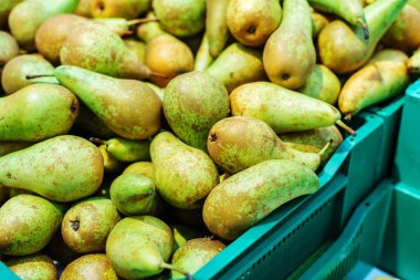 Green pears in a plastic box. Wholesale and retail fruit trade. Close-up