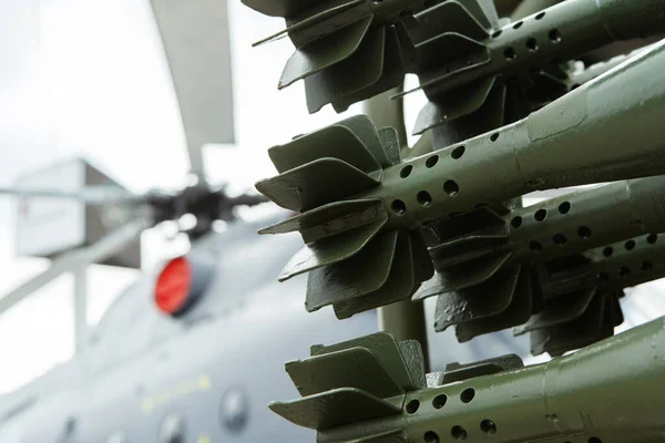 A fragment of a mortar shell against the background of a military helicopter. Light artillery ammunition close up