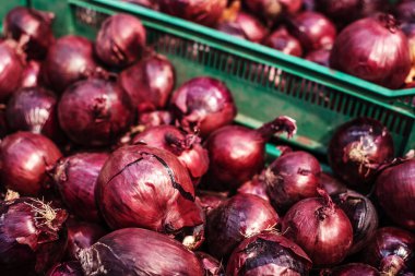 Red onions in a plastic box. Wholesale and retail trade in vegetables. Close-up