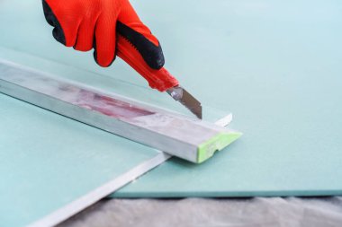 İnşaat bıçağıyla alçıpan kesin. Yakın plan. Yan görünüm