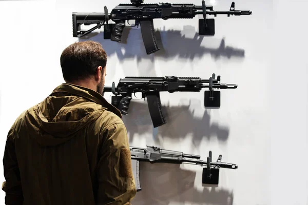 Ein Mann Untersucht Einen Stand Mit Modernen Schusswaffen Sehen Sind — Stockfoto