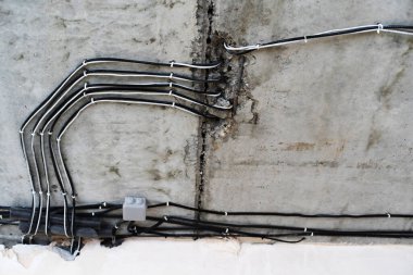 İnşaat halindeki bir eve elektrik kabloları döşenmiş. İnsan yok. Yakın plan.