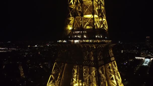 Foto nocturna desde un dron de una parte de la Torre Eiffel con un restaurante. — Vídeos de Stock