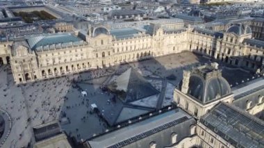 Merkezinde cam kubbe olan Louvre Müzesi 'nin dairesel drone görüntüsü..
