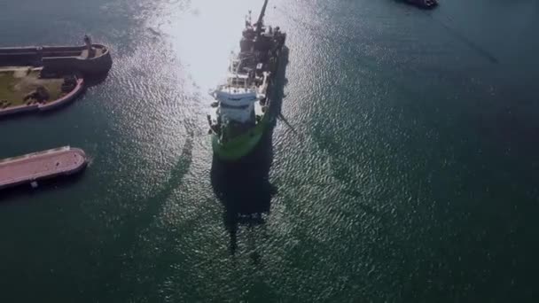 Pohled na malou nákladní loď s jeřábem vplouvajícím do přístavu. — Stock video