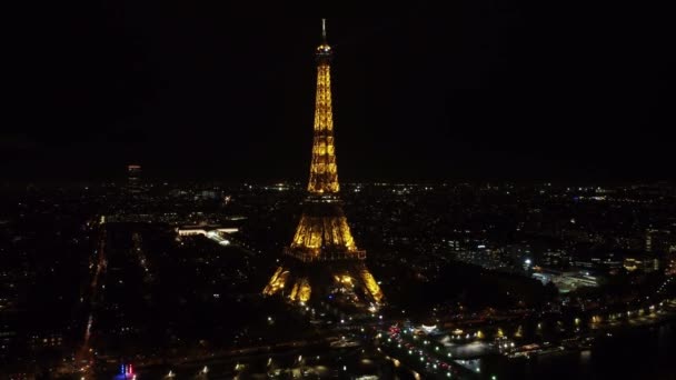 Static aerial footage of Paris at night and the glowing Eiffel Tower. — стоковое видео