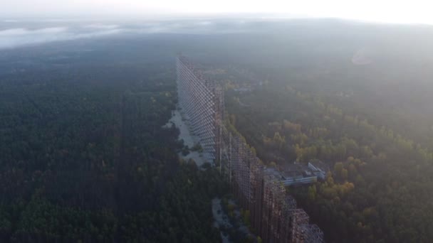 Morning shot from Duga radar drone against the backdrop of a foggy forest. — Video