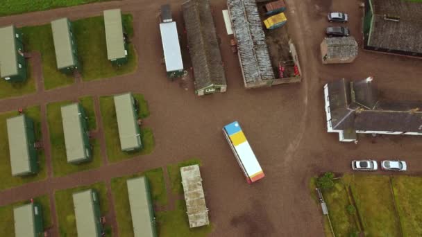 Drone uitzicht op caravans en een dubbeldekker bus met landarbeiders. — Stockvideo