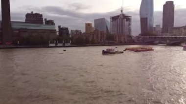 Thames nehri boyunca 2 kargo karavanı çeken küçük bir teknenin insansız hava aracı görüntüleri..