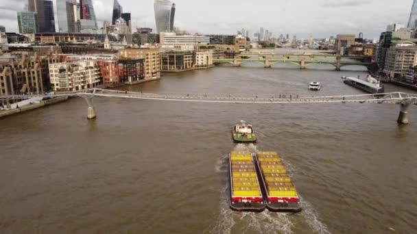 An aerial shot of a cargo ship sailing under a footbridge. — Wideo stockowe