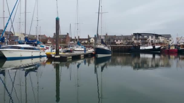 Barcos aparcados y casas frente al mar se reflejan en el agua. Vista del dron. — Vídeo de stock