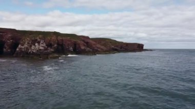 Kayalık kıyılarda sörf yapan bir deniz insansız hava aracından hızlı bir çekim..