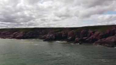 İnsansız hava aracı yüksek kayalık kıyılarda uçuyor..