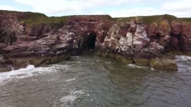 The drone flies off the rocks on the coast of the North Sea.