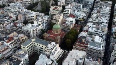 Drone view of an Orthodox church in Athens surrounded by square blocks