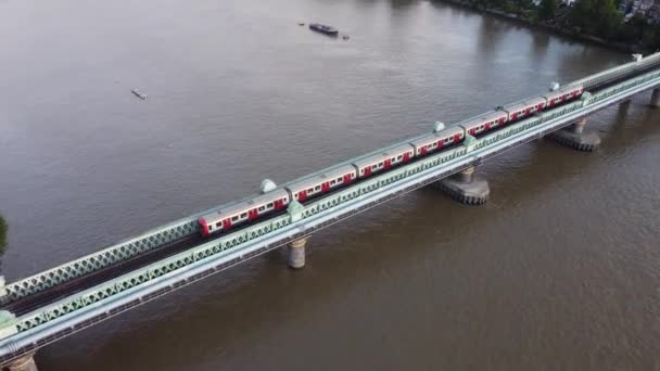 A drone view of a tube train on the Fulham Railway Bridge in London. — Stock Video