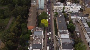 Yeşil bir parkın yanındaki güzel bir İngiliz caddesinin insansız hava aracı manzarası.